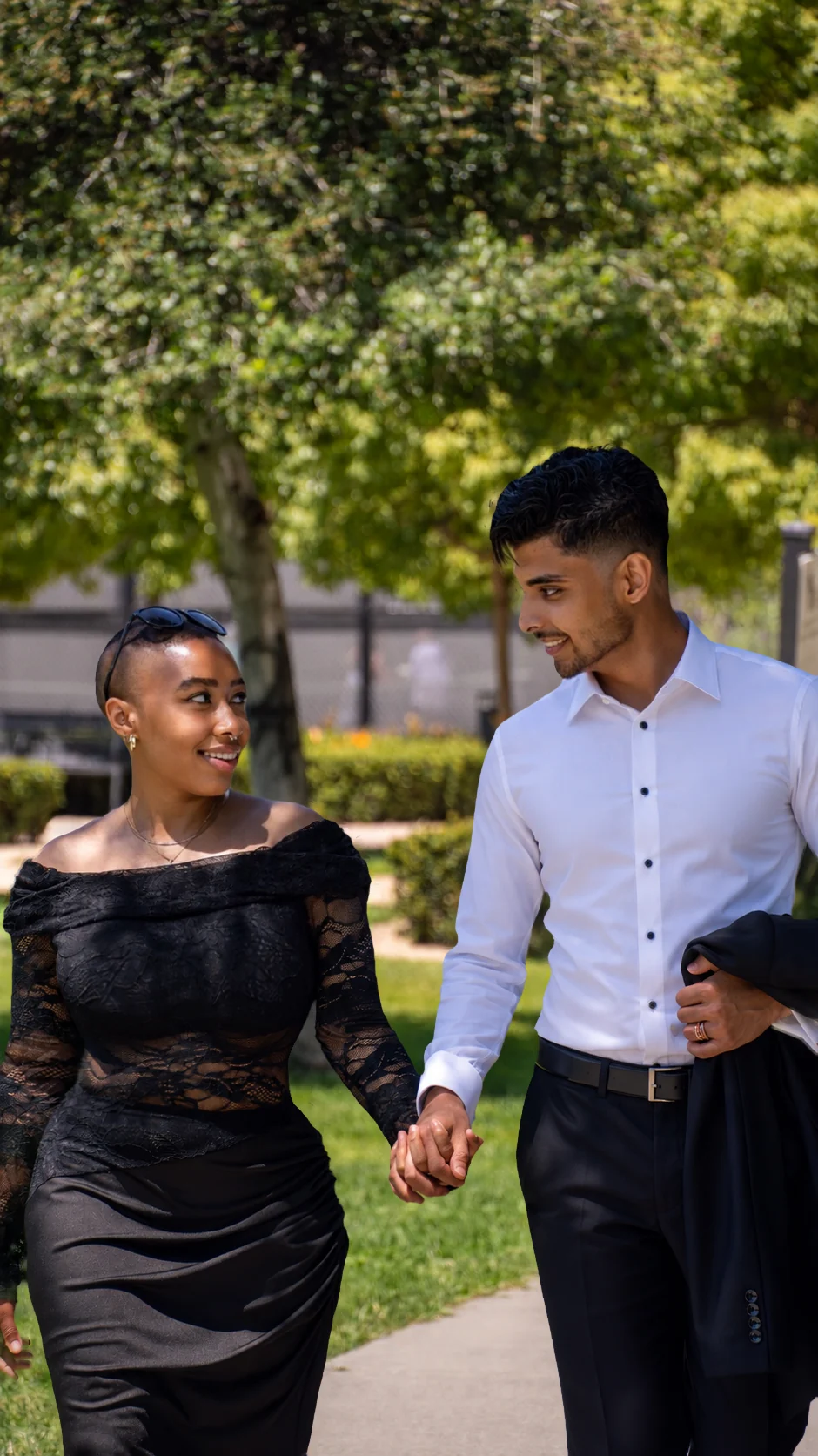 Akshat and Jade holding hands as they walk through the park
