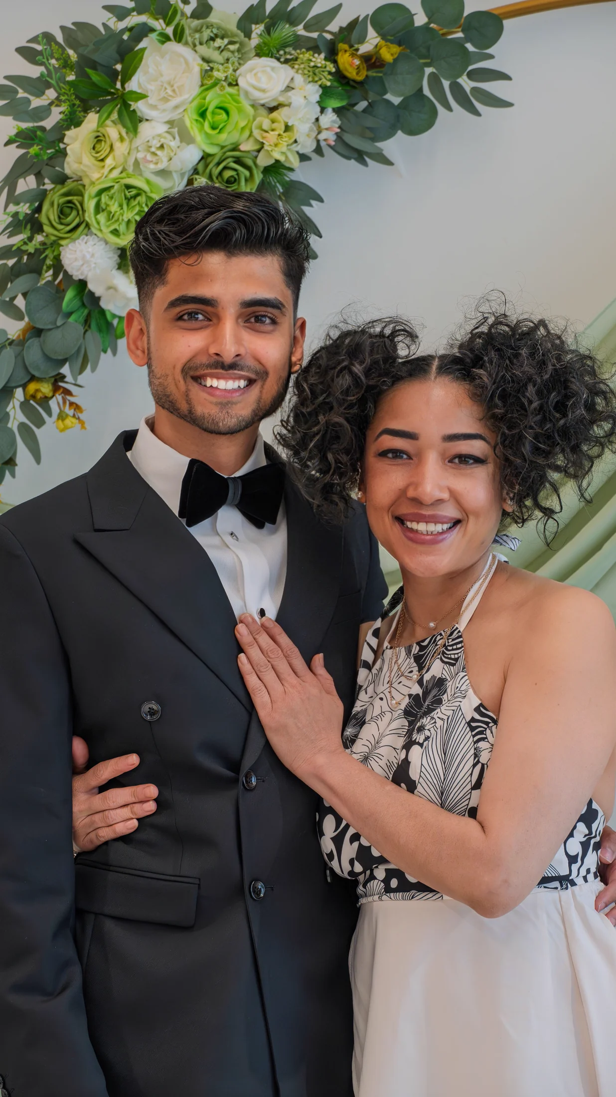 Akshat smiling with his mother-in-law beneath the ceremony arch